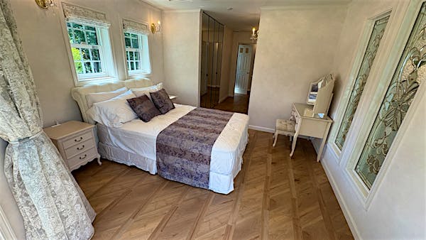 2F主寝室、約11帖。鏡張りのクローゼットが特徴的。南側と西側の２面採光。